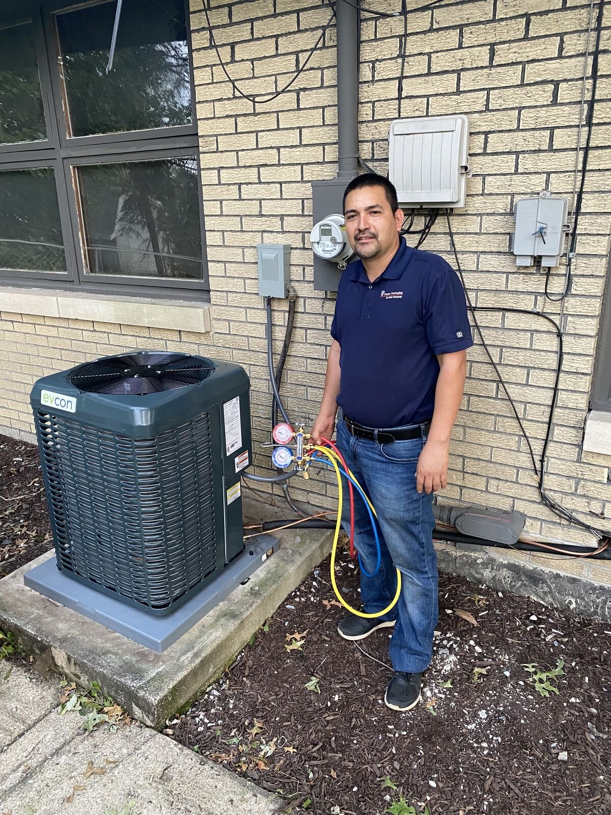 Technician charging refrigerant on new install
